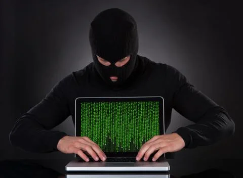 Hacker stealing data of a laptop computer Stock Photos
