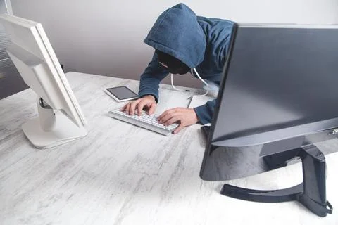 Hacker stealing information from the office computer. Hacking, Criminal Stock Photos