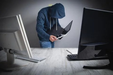 Hacker stealing information from the office computer. Hacking, Criminal Stock Photos