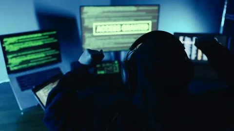 Hacker successfully using code designing virus system, raised hands celebrating. Stock Photos