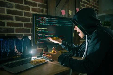 Hacker surprised looking at many bitcoin money 스톡 사진