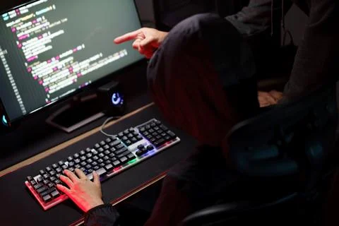 Hacker team using smartphone and typing code on keyboard to hacking program.. Photos