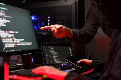 Hacker team using smartphone and typing code on keyboard to hacking program.. Photos