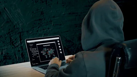 Hacker tracing contact on laptop computer. Man in hood sits at table dark night 스톡 동영상 82892258