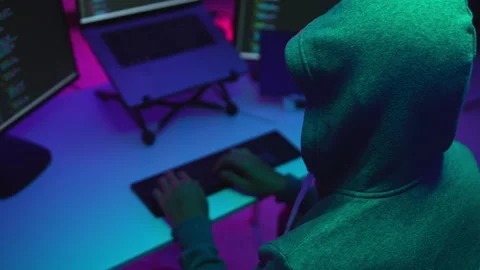 Hacker Typing Code in a Cyber Environment Surrounded by Computer Screens Stock Footage 336678506