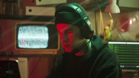 Hacker typing on keyboard at night, breaking password, wearing headphones with Stock Footage 158926344