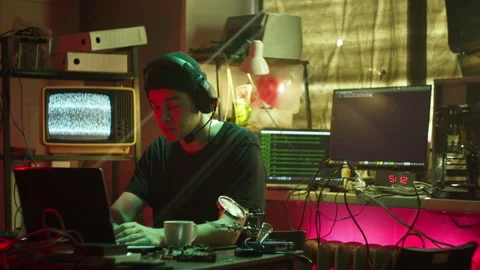 Hacker typing on keyboard at night, breaking password, wearing headphones with 動画素材 158927868