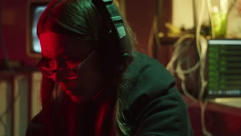 Hacker typing on keyboard at night, breaking password, wearing headphones and Stock Footage 161178036