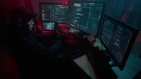 Hacker typing virus code on multiple monitors of computer Stock Footage 257381739