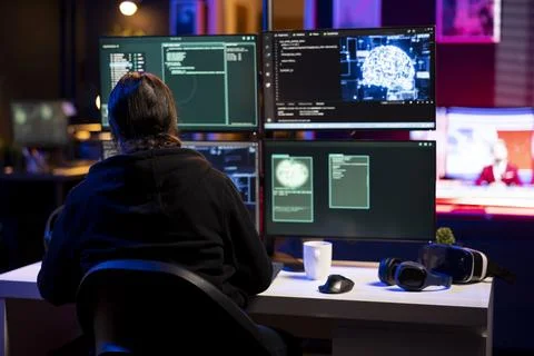 Hacker in underground lair installing spyware secretly gathering data Foto stock