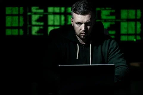 Hacker uses laptop for hacking activity. Hacker analyzes encryption and firewall Stock Photos