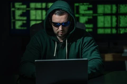 Hacker uses laptop for hacking activity. Hacker analyzes encryption and firewall Stock Photos