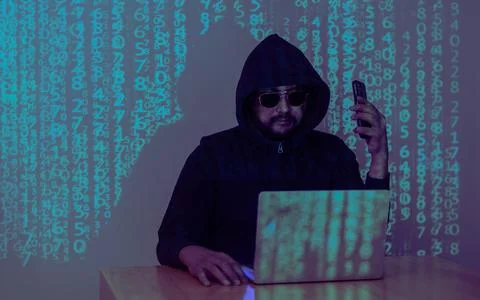 A hacker uses a malware with mobile phone and laptop to hack password the p.. Stock Photos