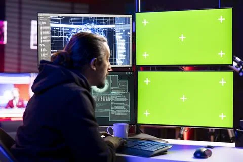 Hacker using artificial intelligence on green screen PC to steal credit cards Foto stock