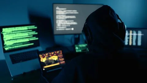 A Hacker using computer breaks into data servers and infects systems with virus. Stock Photos