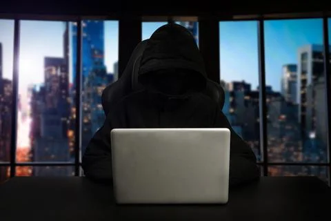 Hacker using computer with digital interface while sitting at desk of blurry Stock Photos