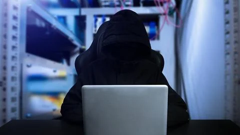 Hacker using computer with digital interface while sitting at desk of blurr.. Fotos Stock