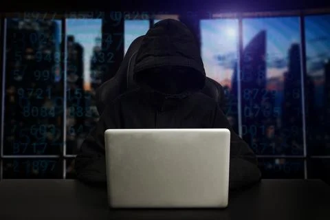 Hacker using computer with digital interface while sitting at desk of blurr.. Stock Photos