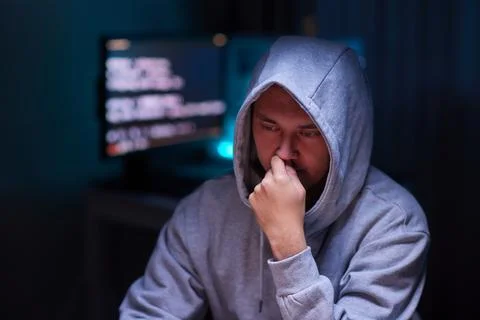 Hacker using the computer. Man in a hoodie breaks the access to steal 스톡 사진