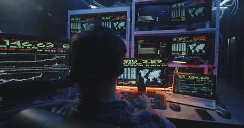 Hacker using computer with multiple monitors Foto stock