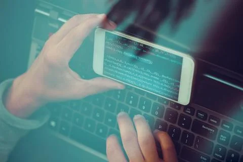 Hacker using computer, smartphone and coding to steal password and private... Foto stock