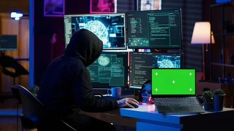 Hacker using green screen laptop to deploy malware on unsecured devices Foto stock
