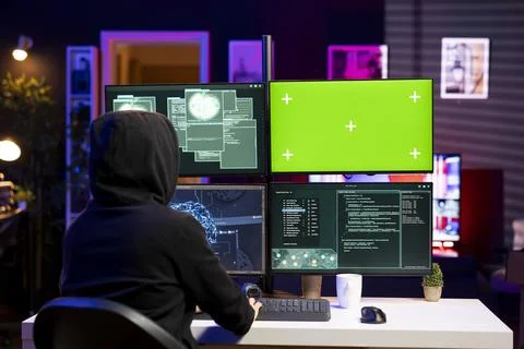 Hacker using green screen PC, coding malware designed to exploit backdoors Foto stock