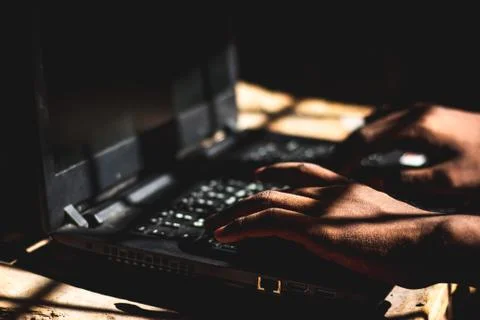 The Hacker using his laptop computer to open Dark web sites at Indoor Dark Ro Foto stock