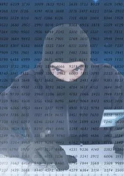 Hacker using a laptop and holding a credit card behind a digital screen Foto stock