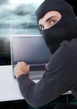 Hacker using a laptop and watching the lens 스톡 사진