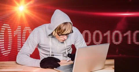 Hacker using laptop with binary code in background 写真素材