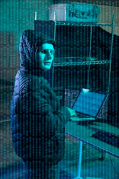 Hacker using laptop with binary code 库存照片