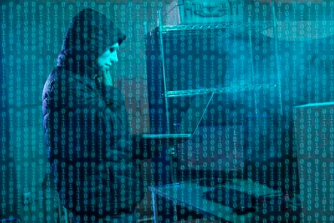 Hacker using laptop with binary code Foto stock