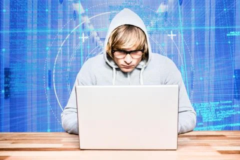 Hacker using a laptop with a blue digital background 스톡 사진