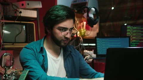 Hacker using laptop close-up. Young Spanish man developing program in dark room Stock Footage 166319316