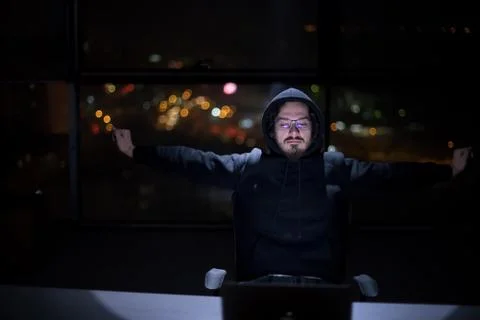Hacker using laptop computer while working in dark office 스톡 사진