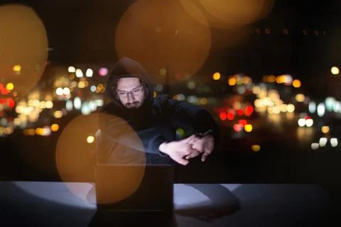 Hacker using laptop computer while working in dark office 스톡 사진