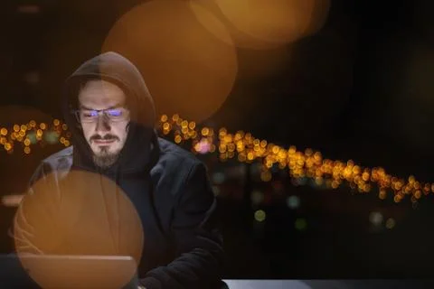 Hacker using laptop computer while working in dark office 스톡 사진