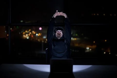 Hacker using laptop computer while working in dark office 스톡 사진