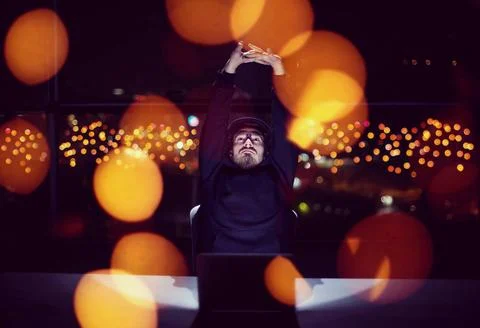 Hacker using laptop computer while working in dark office Young talented h... Stock-Fotos