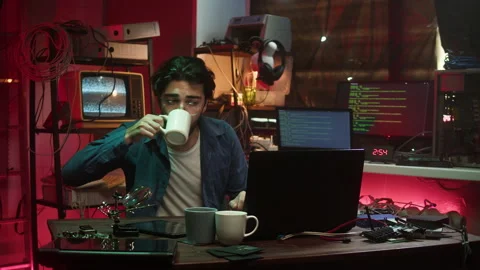 Hacker using laptop, drinking coffee. Young Spanish man developing program in Stock-Footage 164414746