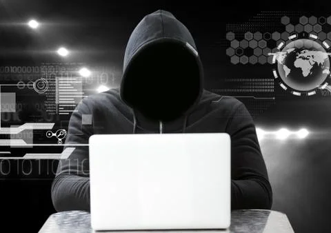 Hacker using a laptop in front of dark background with digital icons 写真素材