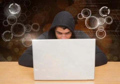 Hacker using a laptop in front of digital orange background 写真素材