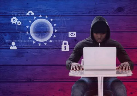 Hacker using a laptop in front of wood background with digital icons Foto stock