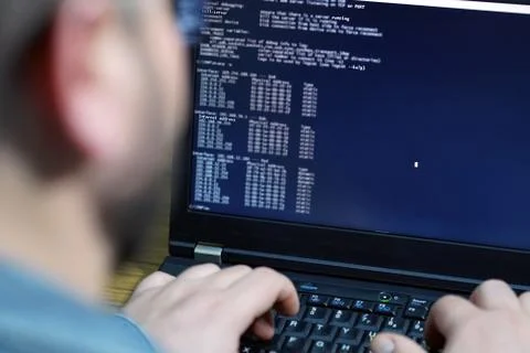 Hacker using laptop. Lots of digits on the computer screen Stock Photos