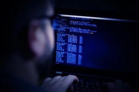 Hacker using laptop. Lots of digits on the computer screen Stock Photos