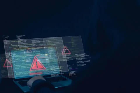 Hacker using laptop with warning alert symbol on screen, representing cyber.. 库存照片