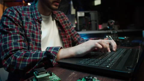 Hacker using laptop. Young man developing program in dark room. Professional Video stock 166859329