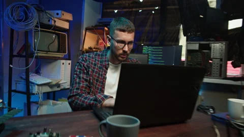 Hacker using laptop. Young man developing program in dark room. Professional Video stock 167049357