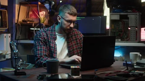 Hacker using laptop. Young man developing program in dark room. Professional Video stock 175839055